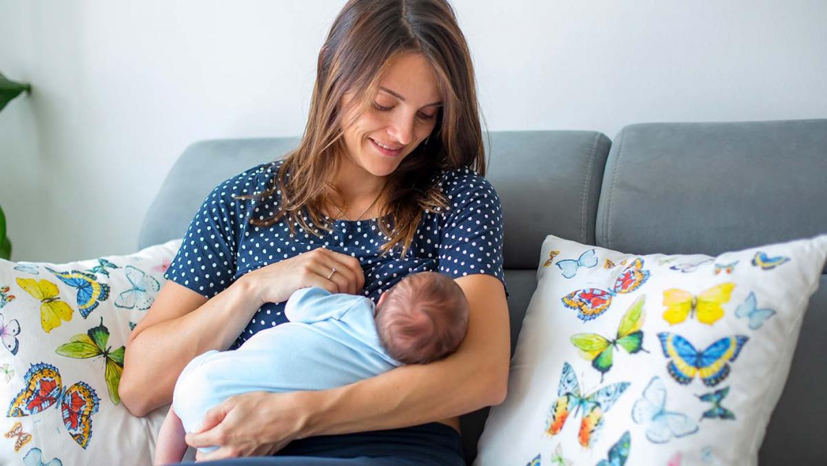 Attractive mother breastfeeds her baby