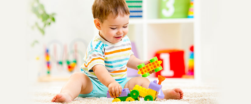 Baby boy playing indoors with his lego