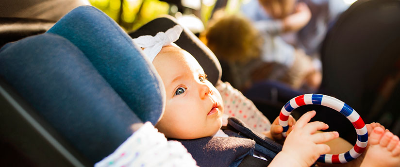 Baby boy in a car seat on a trip