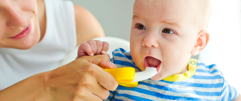 Mother brushing her baby's teeth