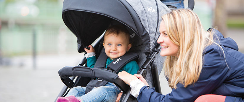 Mother plays with her child and a stroller
